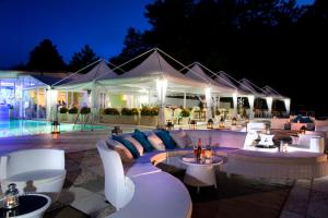 a patio with white couches and tables at night at Hotel Posta in Chianciano Terme