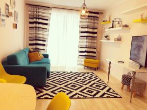 a living room with a blue couch and a rug at Belle View Apartment Brasov in Braşov