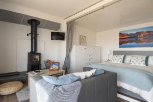 a bedroom with a bed and a couch and a fireplace at Columba Lodge, St Conan's Escape, Idyllic highland getaway in Dalmally