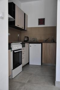 a kitchen with a stove and a white refrigerator at The white House (studio apartment) in Palamarca