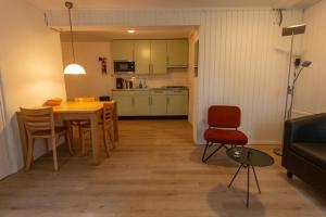 eine Küche und ein Esszimmer mit einem Tisch und Stühlen in der Unterkunft Folkshegeskoalle Schylgeralân in Hoorn