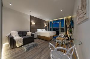 a bedroom with a bed and a couch and a table at VICTORY-21 LUXURY APARTMENT CEnTER in Kyiv