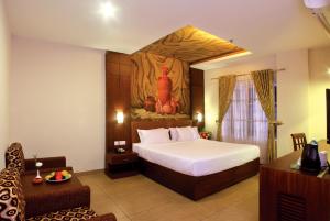 a bedroom with a bed and a painting on the wall at Clay House in Trichūr +27 photos