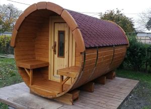 a large wooden hobbit house with a round door at Lepkés Vendégház in Poroszló