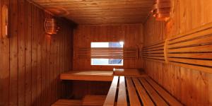 a wooden sauna with a bench and a window at City Hotel in Bydgoszcz