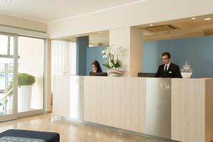 two people standing at a reception desk in a lobby at Hotel Las Vegas in Lido di Jesolo