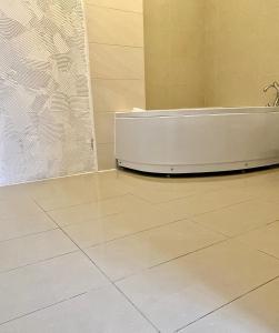 a white bath tub sitting in a bathroom next to a wall at Hotel Akor in Bydgoszcz