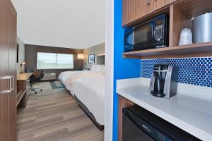a hotel room with a bed and a microwave at Holiday Inn Express- Eau Claire West I-94 by IHG in Eau Claire