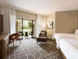 a hotel room with a bed, chair, and table at Fairmont Scottsdale Princess in Scottsdale