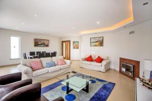a living room with two couches and a fireplace at Villa Rafaella II Palace by Atlantic Places in Albufeira