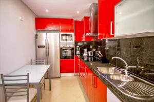 a kitchen with red cabinets and a counter top at Villa Rafaella II Palace in Albufeira