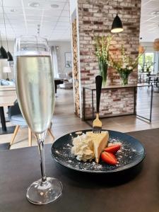a glass of wine and a plate with cheese and vegetables at Tulipanowy Gościniec in Jantar