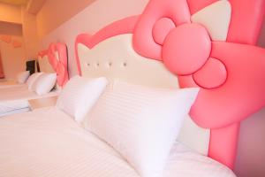 馬公市的住宿－波莉士的家民宿，一间卧室配有两张床和粉红色床头板