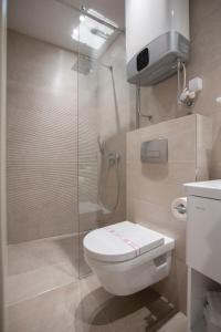 a bathroom with a toilet and a glass shower at Hotel Vela in Budva