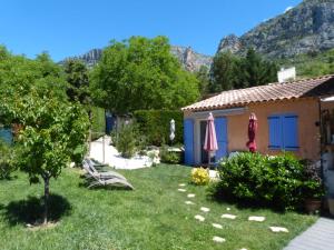 a small garden with a house and mountains in the background at Chambre d'Hôtes L'Odalyre in Moustiers-Sainte-Marie