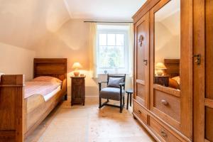 a bedroom with a bed and a chair and a window at Landhaus Camillas Höhe in Mirbach