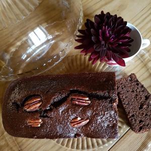 un gâteau au chocolat sur une assiette avec une tasse de café et une fleur dans l'établissement chambres d'hôtes du Tilleul, à Nanteuil-en-Vallée