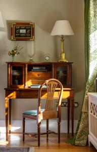a wooden desk with a chair and a lamp at Sheen Falls Lodge in Kenmare