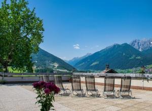 a group of chairs sitting on a patio with mountains at Panorama-Ferienhaus im Stubaital in Mieders