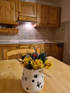 a vase of flowers sitting on a table in a kitchen at Appartamento Gentiana psdCIR0037 in Pré-Saint-Didier