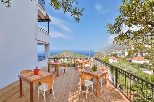 a balcony with tables and chairs and a view of the ocean at Elit Hotel Kas in Kaş