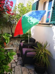 una sombrilla colorida sentada en un patio en Caparica Surf Villa, en Costa da Caparica