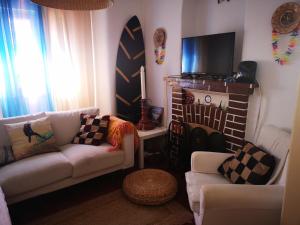 un soggiorno con divano e tavola da surf di Caparica Surf Villa a Costa da Caparica