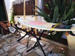 een surfplank op een stand naast een plant bij Caparica Surf Villa in Costa da Caparica