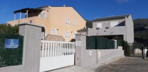 a white fence in front of a house with a gate at Porteo - Les Terrasses du Port in Centuri