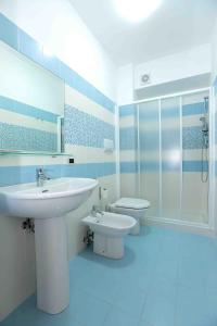 a blue and white bathroom with a sink and a toilet at Il Gabbiano - Case Vacanze in Capo dʼOrlando