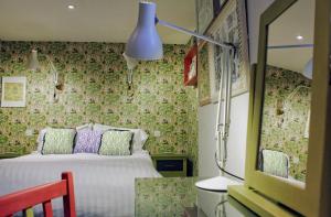 um quarto com uma cama, um candeeiro e um espelho em The Fountaine Inn em Linton