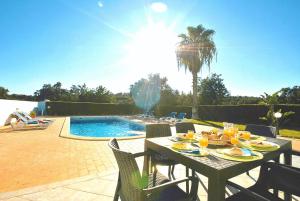 einen Tisch mit Essen darauf neben einem Pool in der Unterkunft Villa Martinica by Algarve Vacation in Guia