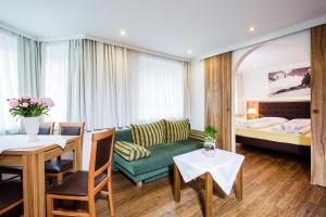 une chambre d'hôtel avec un canapé, une table et un lit dans l'établissement Neue Post - Apartments, à Zell am See