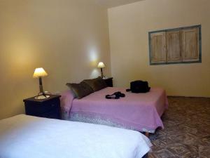 una camera con due letti e una borsa sul letto di El Indio - Casa de campo a Villa del Salvador Altre 37 foto