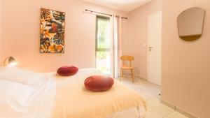 a bedroom with a bed with red pillows on it at "Le Soleil Levant" avec balcon et parking privé, 2 adultes et 1 enfant in Sarlat-la-Canéda
