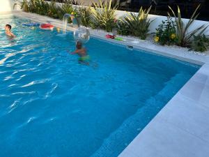 聖地亞哥拉里韋拉的住宿－Villa floralize，两人在游泳池玩球
