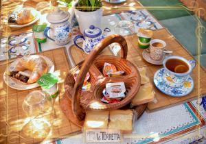 una mesa cubierta con una cesta de pan y queso en B&B La Torretta, en Maratea
