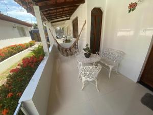 a porch with a hammock and a table and chairs at Casa 4/4(Amplos), Cond. fechado com piscina-150m2 in Salvador