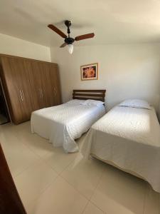 1 dormitorio con 2 camas y ventilador de techo en Casa 4/4(Amplos), Cond. fechado com piscina-150m2, en Salvador