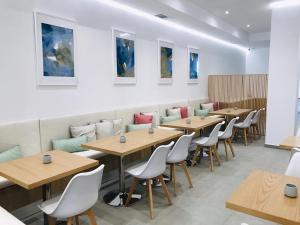 une rangée de tables et de chaises dans un restaurant dans l'établissement The Convo Athens Riviera, à Athènes