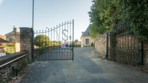 una entrada a una entrada con una puerta de hierro forjado en "Le Soleil Levant" avec balcon et parking privé, 2 adultes et 1 enfant, en Sarlat-la-Canéda