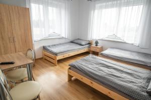 1 dormitorio con 2 camas, mesa y silla en Dwa Karpie Jedlicze, en Jedlicze