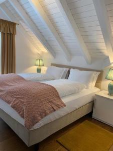 1 dormitorio con 1 cama blanca grande y 2 lámparas en ApartamentS en Rîşnov