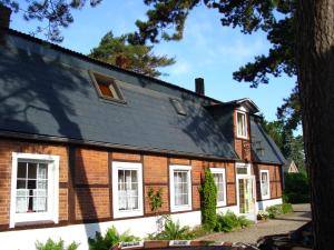 una casa de ladrillo con ventanas blancas y techo negro en Landhaus Voß, en Timmendorfer Strand