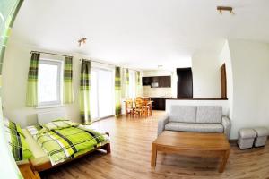 ein Wohnzimmer mit einem Bett, einem Sofa und einem Tisch in der Unterkunft Apartmány Ráztoky in Liptovský Mikuláš