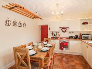 a kitchen and dining room with a table and chairs at Shiel Cottage in Thornhill