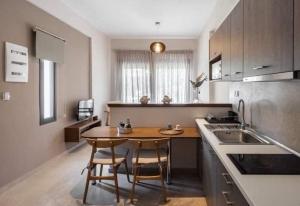 a kitchen with a table and chairs in a kitchen at PLOUMIS seaside villas in Stavros
