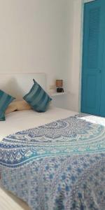Una cama con almohadas azules encima. en Apartamento a 50m de la playa - Ideal familia, en Miami Platja