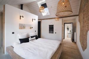 - une chambre avec un grand lit blanc dans l'établissement Boutique Holiday Home Zalig In Antwerpen, à Anvers