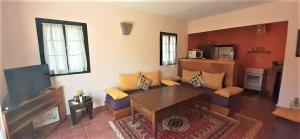 ein Wohnzimmer mit einem Sofa und einem Tisch in der Unterkunft Maison Marocaine Agadir in Agadir